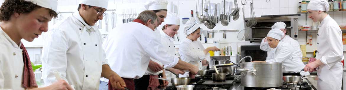 A Chef helping other chefs with cooking.